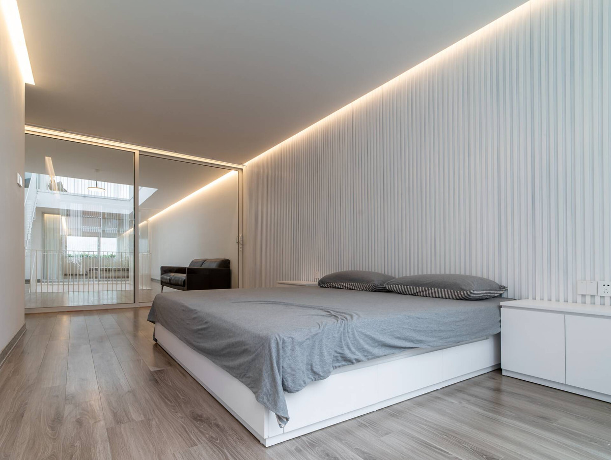 Phòng ngủ thiết kế tối giản với cửa kính trượt lớn để tạo cảm giác rộng rãi.