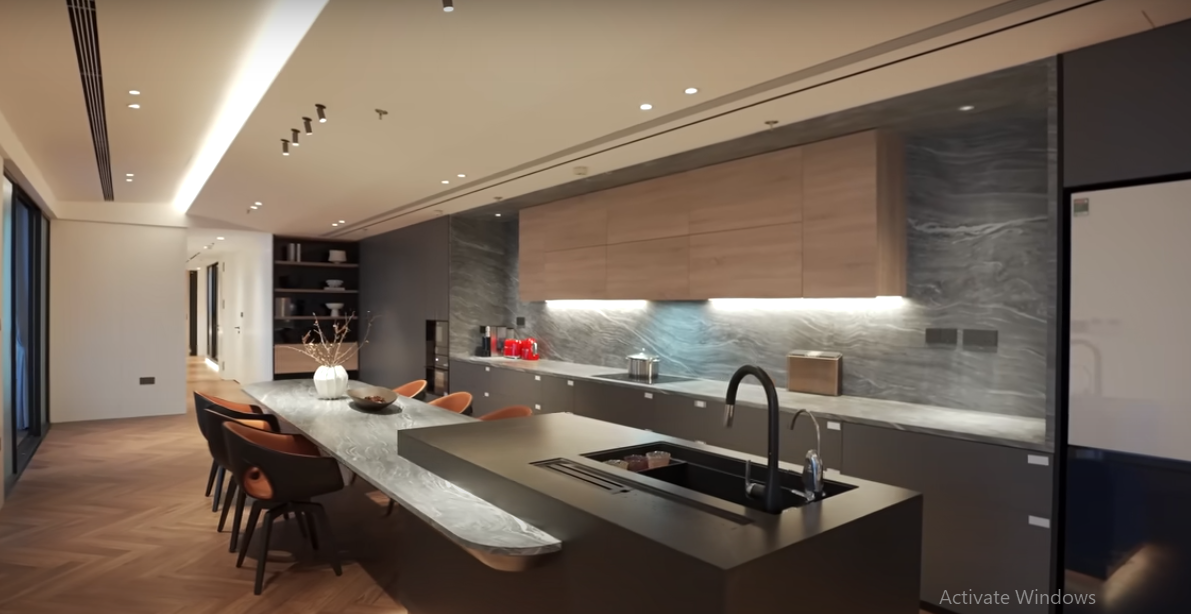 Phòng bếp hiện đại với bàn ăn bằng gỗ được ốp đá tự nhiên.