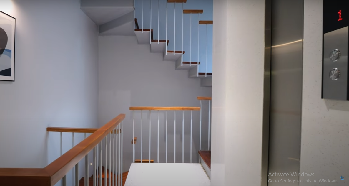 Do nhà có 6 tầng nên lắp thang máy là rất cần thiết. Cầu thang bộ thiết kế ấn tượng với lan can gỗ kết hợp thanh kim loại.