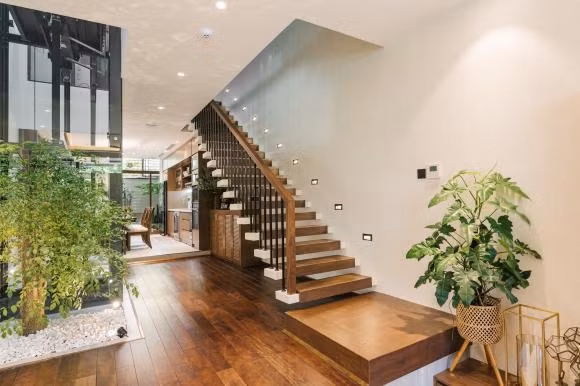 Nội thất trong nhà sử dụng tông trắng, nâu chủ đạo, điểm xuyết màu xanh của cây cối.