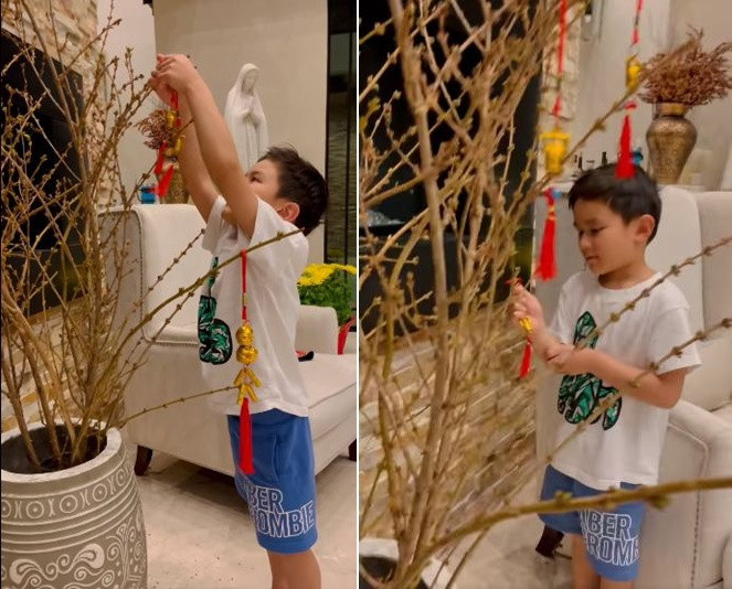 Bé Thiên Từ đã biết giúp mẹ trang trí cành hoa mai.