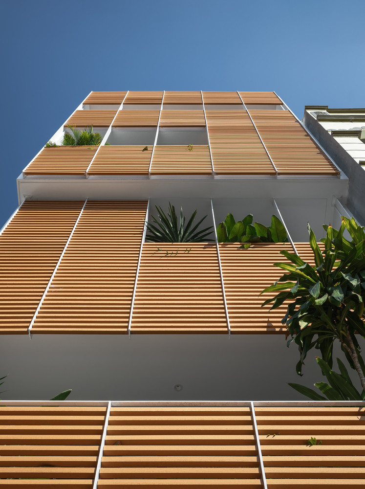 Do đó, bên ngoài căn nhà được bọc một lớp thép gỗ, có ban công phía trước để trồng cây và giảm bớt ánh nắng vào bên trong.