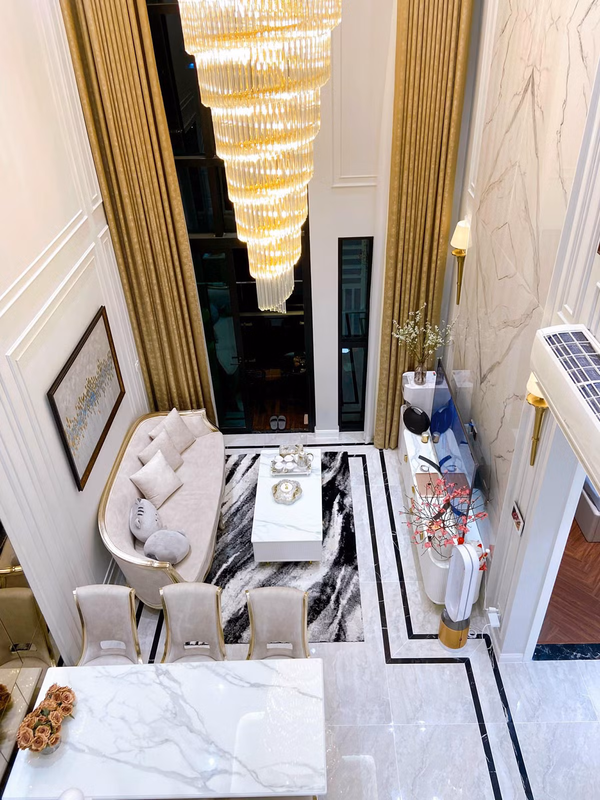 Phòng khách kê bộ sofa cho khoảng 4 - 5 người ngồi. Phía trước là kệ TV, trên là đèn trần thả, phong cách châu Âu. Ảnh: Facebook Lê Phương Thảo