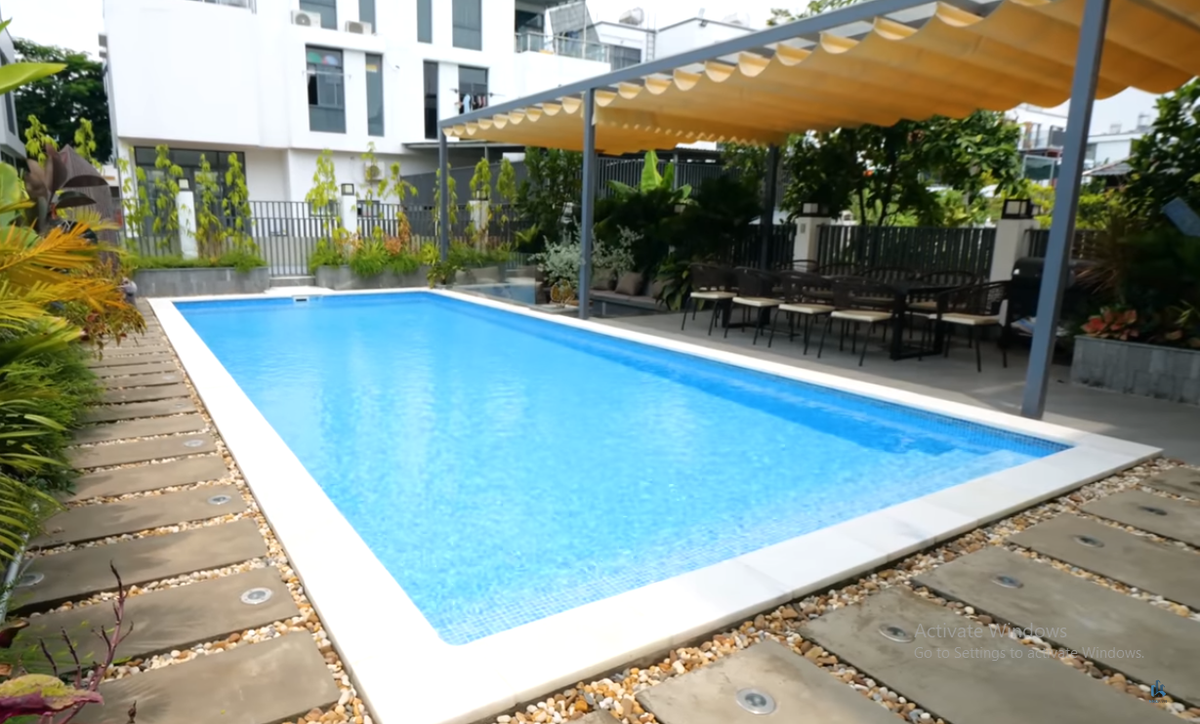 Phía sau nhà là khu vực sân vườn cực kỳ rộng lớn với bể bơi, bếp, bàn ăn và chỗ ngồi thư giãn.