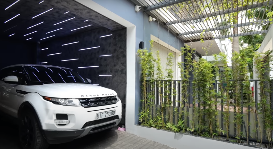 Bước qua cánh cổng là khu vực gara được trang trí đèn bắt mắt.