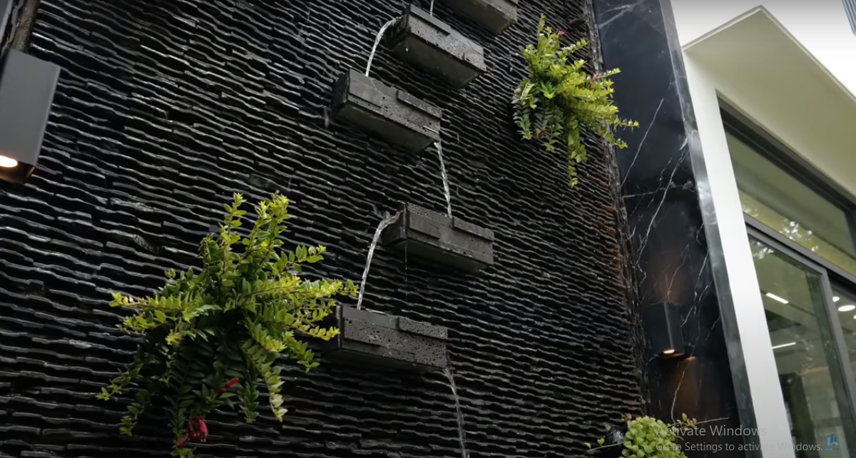 Thiết kế cây xanh và thác nước bên ngoài khiến ngôi nhà phố giống như một căn biệt thự nghỉ dưỡng.