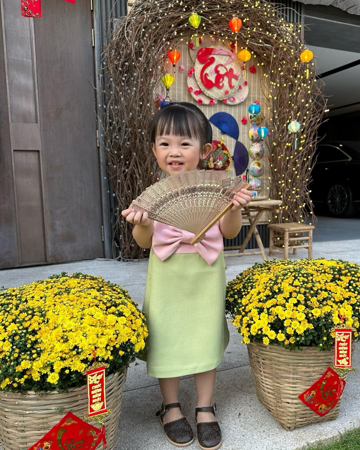 Bé Suchin vui vẻ, thích thú tạo dáng trong không gian đậm không khí tết trước nhà.