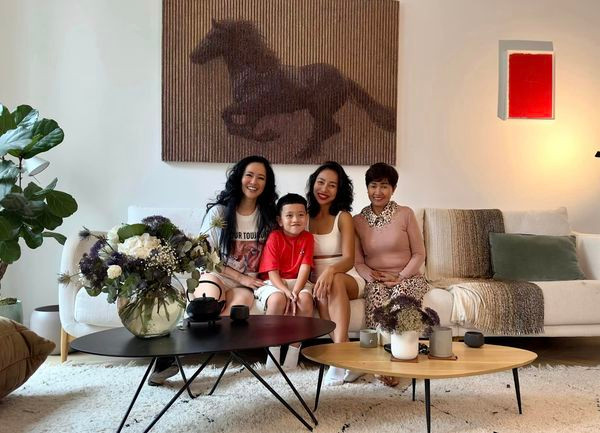 Trong phòng khách có bức tranh ngựa, cây xanh và nhiều lọ hoa tươi đẹp mắt.