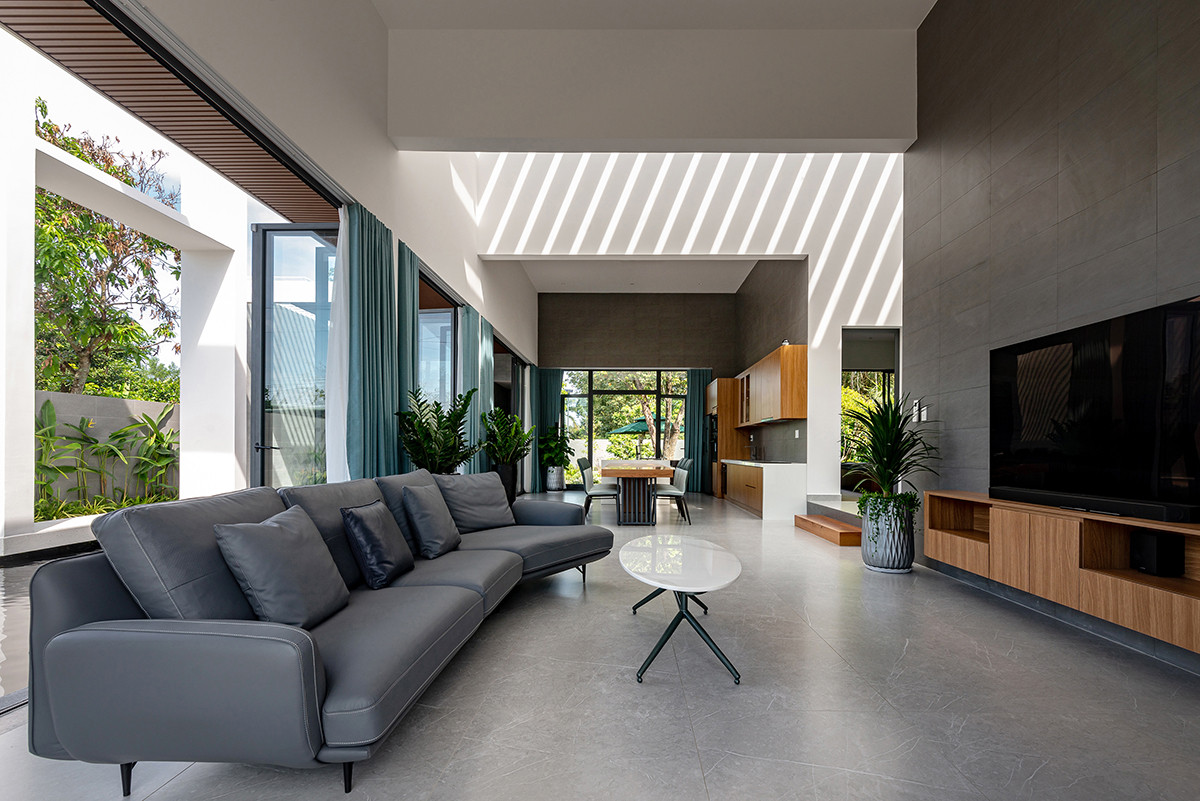 Phòng khách tối giản với điểm nhấn là khung cửa kính lớn mở ra phía ngoài.