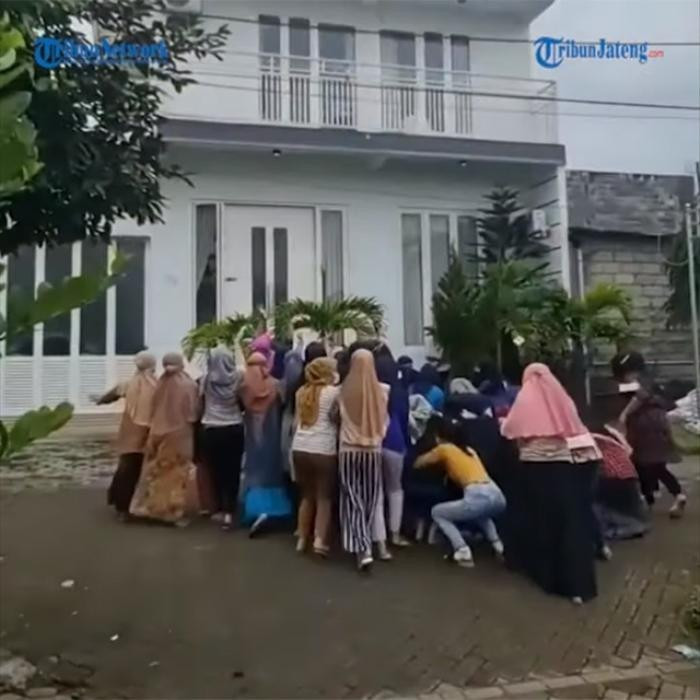 Phía dưới, khoảng chục người đang đứng vừa nhặt tiền vừa vẫy tay cảm ơn. Tổng cộng số tiền người phụ nữ này ném đi lên tới 100 triệu rupiah Indonesia (hơn 162 triệu đồng). Ảnh: Tribunnews