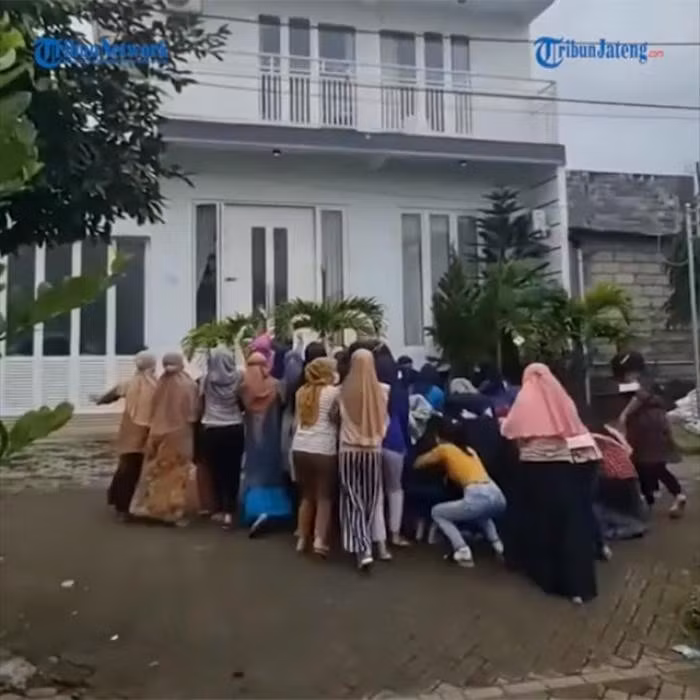 Phía dưới, khoảng chục người đang đứng vừa nhặt tiền vừa vẫy tay cảm ơn. Tổng cộng số tiền người phụ nữ này ném đi lên tới 100 triệu rupiah Indonesia (hơn 162 triệu đồng). Ảnh: Tribunnews