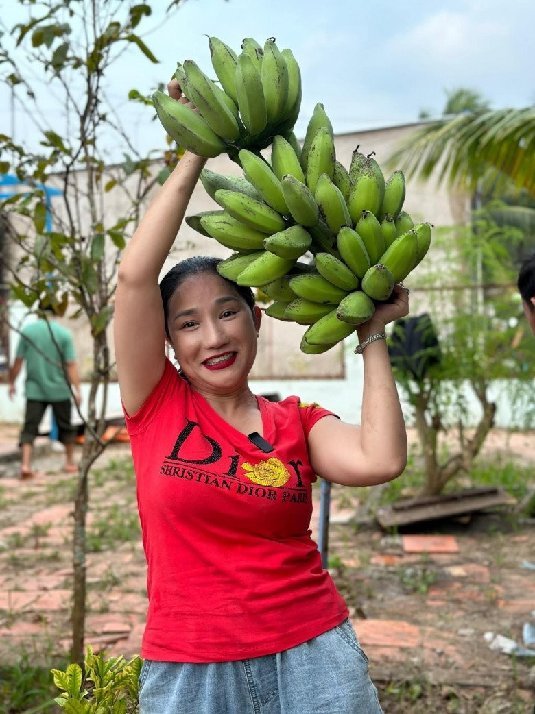 Một lần khác, "bà mối" khoái chí vác buồng chuối lớn vừa chặt trong vườn. Ảnh: FBNV