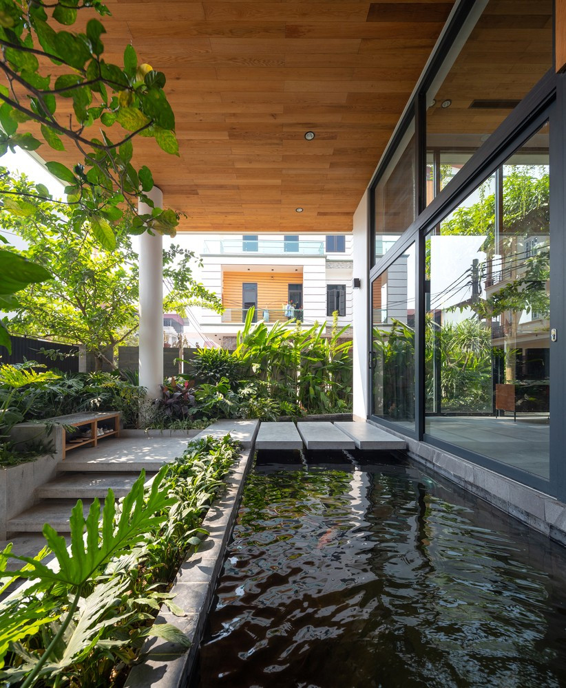 Với màu xám đặc trưng của vật liệu đá kết hợp với các mảng xanh, mặt nước cùng với các mặt trần và hành lang sử dụng vật liệu gỗ, ngôi nhà trở thành một bức tranh hài hòa và gần gũi với thiên nhiên. Nguồn ảnh: Triệu Chiến