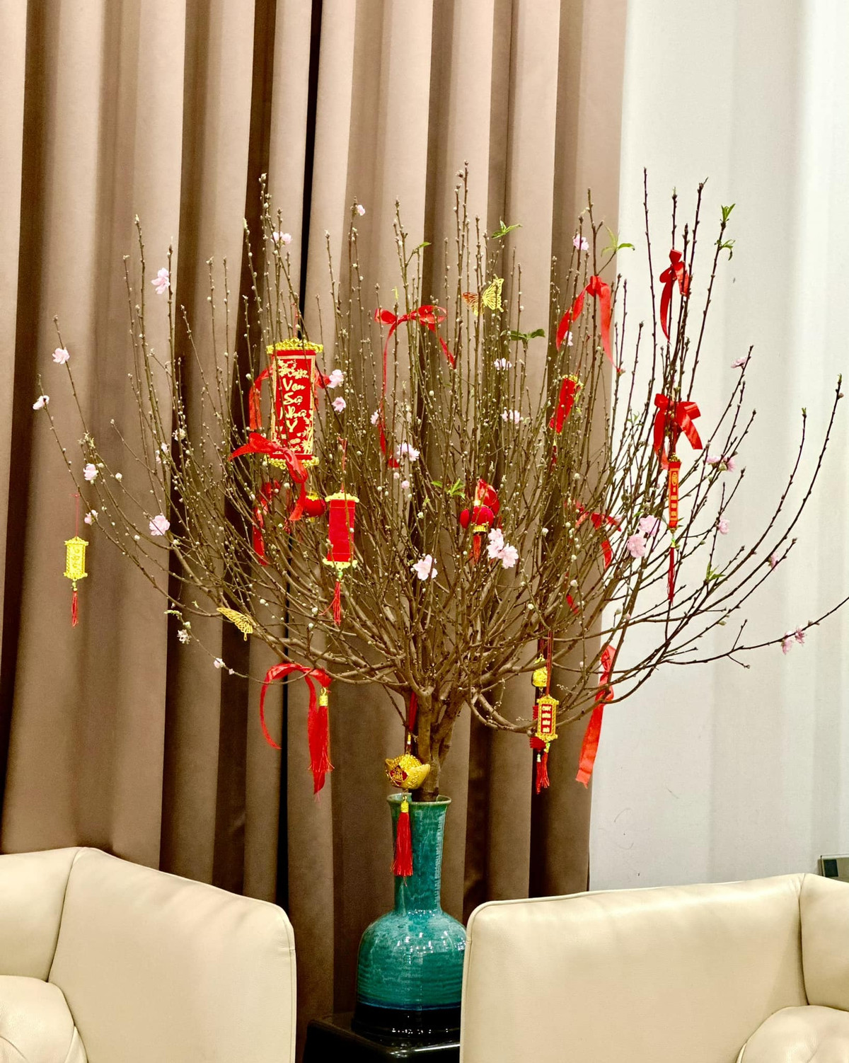 Phòng khách tràn ngập không khí xuân với cành đào nở hoa rực rỡ.