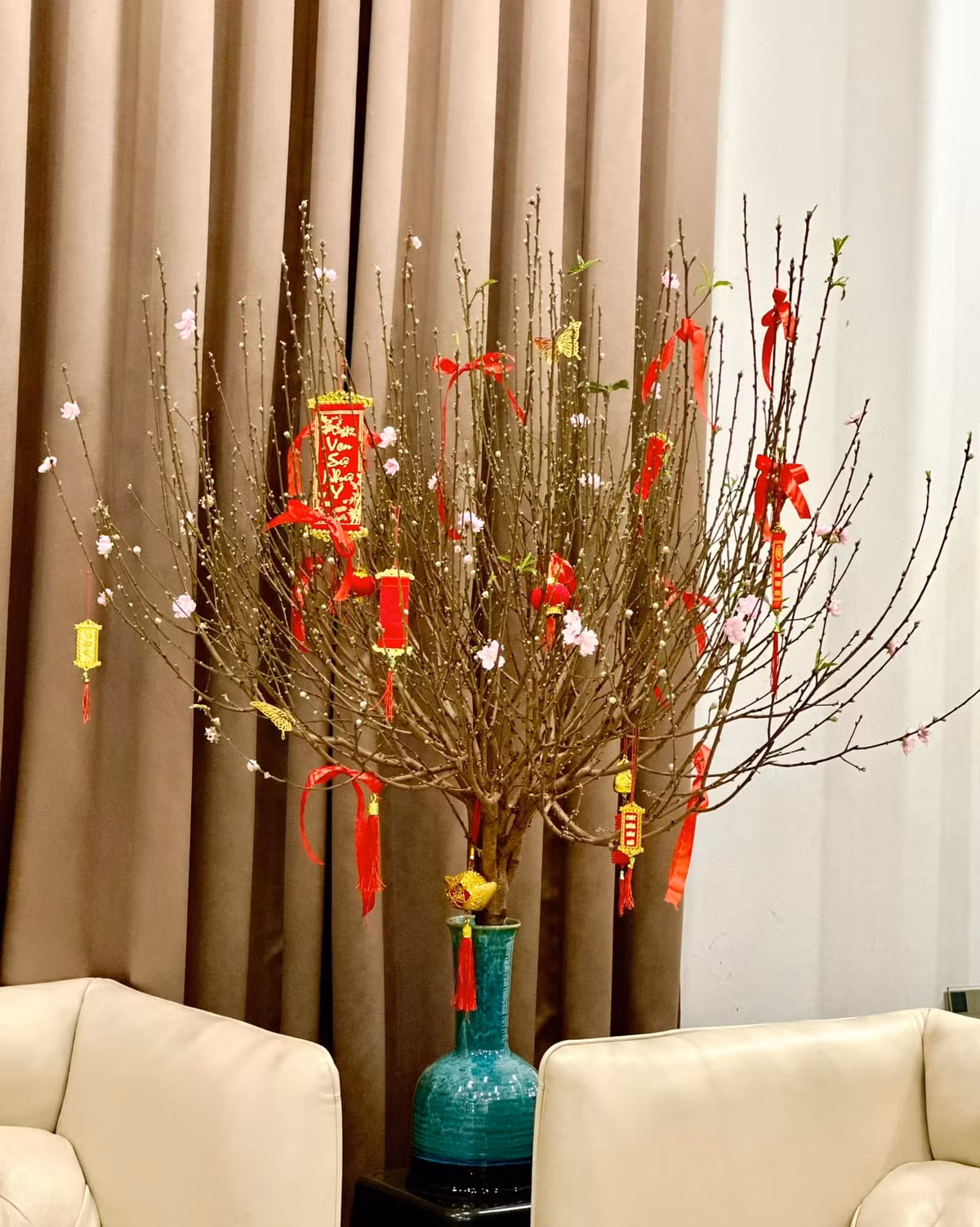 Phòng khách tràn ngập không khí xuân với cành đào nở hoa rực rỡ.