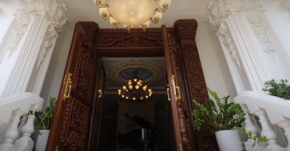 Cửa vào bằng gỗ lim bề thế và trang trí cầu kỳ.