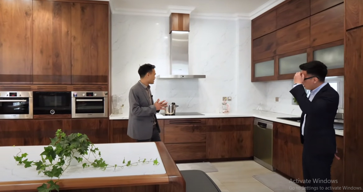 Nội thất phòng bếp chủ đạo là gỗ óc chó, kết hợp với đá sang trọng.