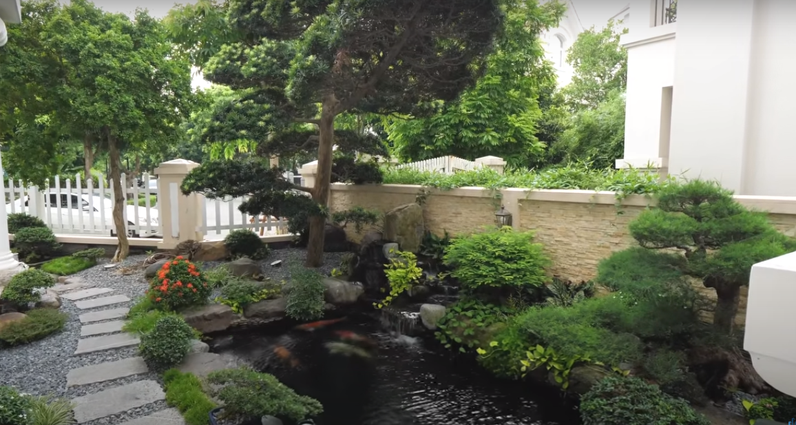 Khu vườn trong nhà được thiết kế theo phong cách vườn Nhật với cây tùng, hồ cá Koi, bàn ghế đá uống trà.