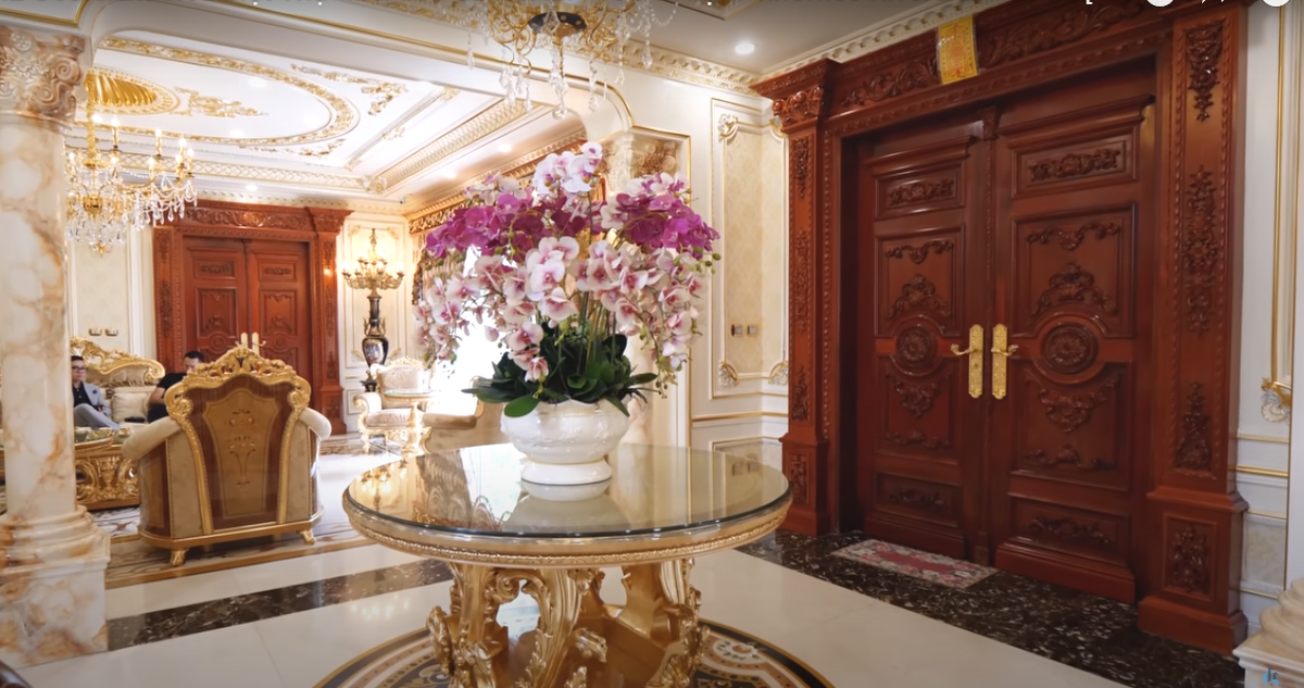 Cửa chính vào căn biệt thự được làm bằng gỗ gõ đỏ Lào bề thế với nhiều chi tiết tinh xảo.