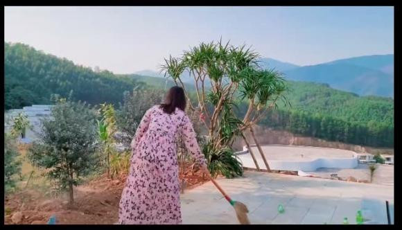 Bà xã Mạnh Trường quét dọn sân, khu vực hồ bơi.