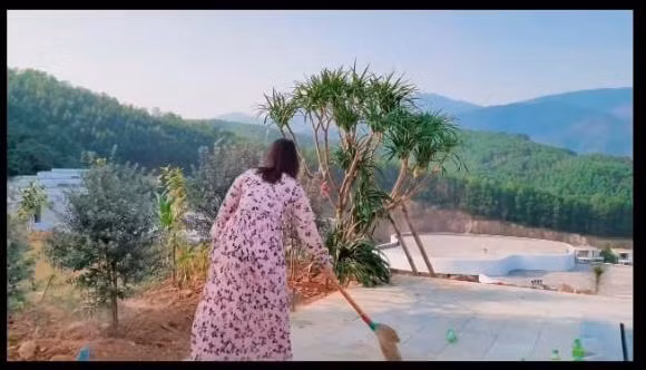 Bà xã Mạnh Trường quét dọn sân, khu vực hồ bơi.