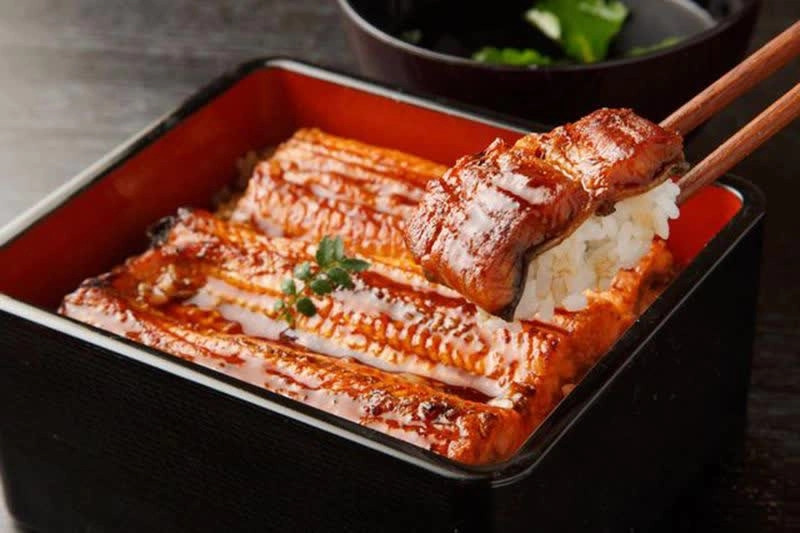 Lươn có thể chế biến thành nhiều món như xiên que, nướng và phết hỗn hợp nước tương với rượu gạo mirin, sau đó đựng trong hộp sơn mài cùng cơm. Mỗi hộp cơm lươn có giá 91 USD, tùy vào giá lươn. Ảnh: Getty