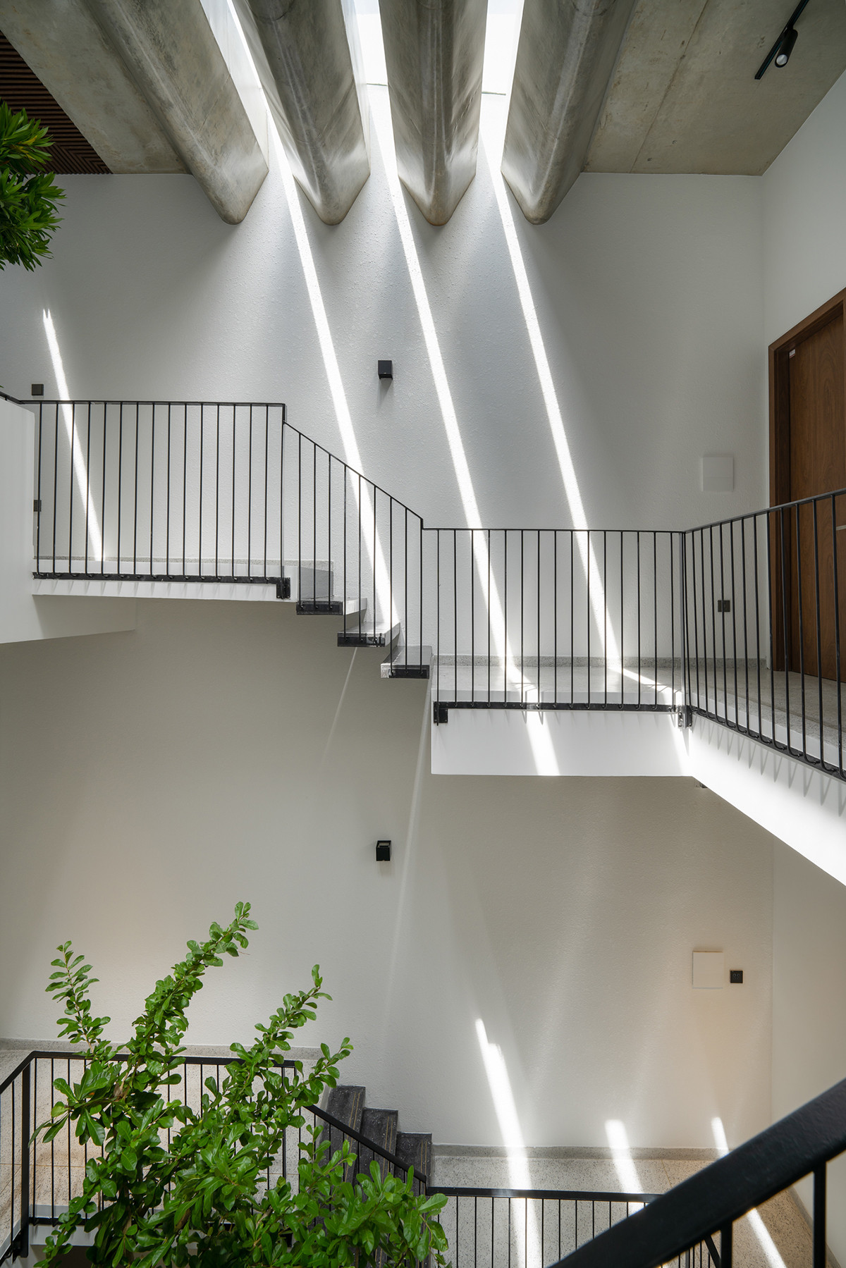 Tại ô thông tầng, kiến trúc sư sử dụng một hệ lam bê tông đúc sẵn thay vì những giải pháp truyền thống. Mục đích là để lấy sáng thành vệt, giúp giảm bức xạ nhiệt cho không gian bên trong.