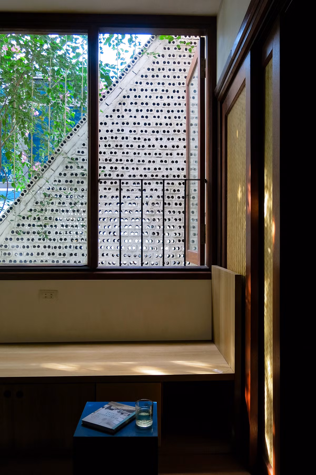 Phòng khách được thiết kế cửa kính lớn và cửa sổ nhìn ra mặt tiền gạch lỗ.