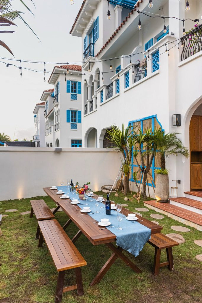 Khuôn viên sân vườn rộng rãi được trải thảm cỏ xanh mướt, có bàn ghế để tổ chức tiệc ngoài trời.