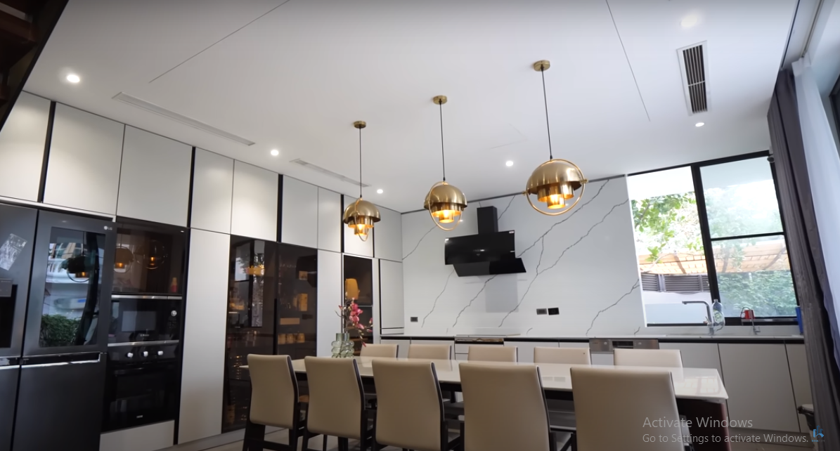 Khu bếp sử dụng gam màu trắng chủ đạo, có tầm nhìn rộng rãi hướng ra bể bơi.