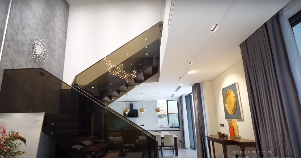 Tại phần chính giữa của căn nhà, gia chủ sử dụng cầu thang khung thép, lan can bằng kính hiện đại.