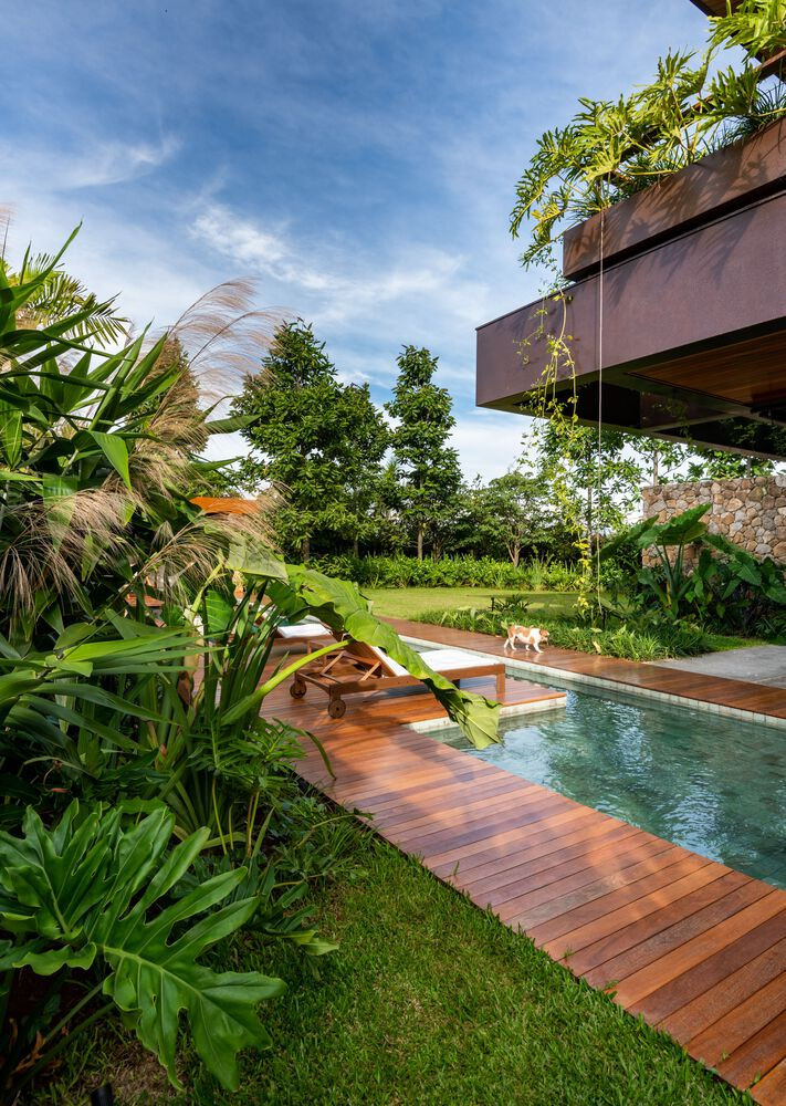 Mái hiên đua rộng giúp tránh mưa nắng, hàng rào cây xanh ngoài lan can giúp ngăn bụi và điều hòa nhiệt độ.