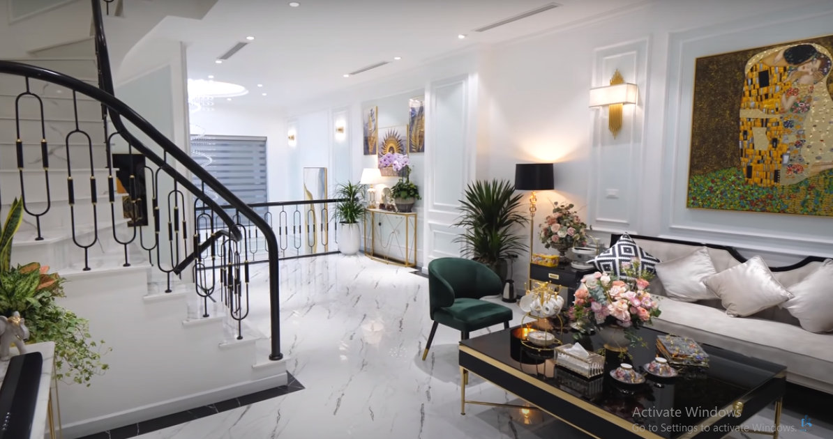 Phòng khách sử dụng gam màu trắng chủ đạo, xen lẫn một số chi tiết màu đen và mạ vàng làm điểm nhấn.