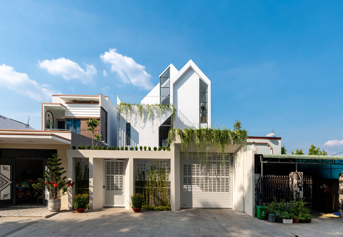 Tầng 1 phía trước nhà là khu để xe có mái che làm bằng hệ lam, nhằm tạo độ thông thoáng nhưng không che chắn tầm nhìn các không gian bên trong.