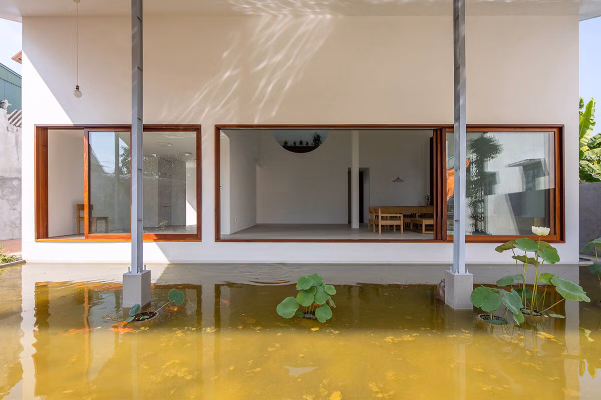 Một nửa hình bán nguyệt phía trước tạo thành mặt nước phía Nam, nửa sau hình bán nguyệt thứ hai là sân nội bộ, mở rộng ra không gian bếp, kết nối với vườn rau và chuồng gà phía sau.