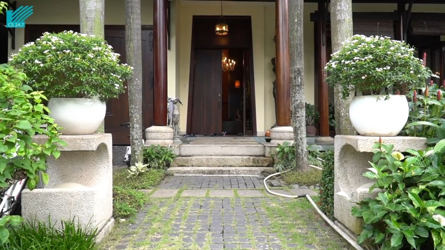 Biệt thự mang đậm phong cách Đông Dương. Lối vào mộc mạc với cửa gỗ và đèn treo bằng tre. Ảnh: 2dep