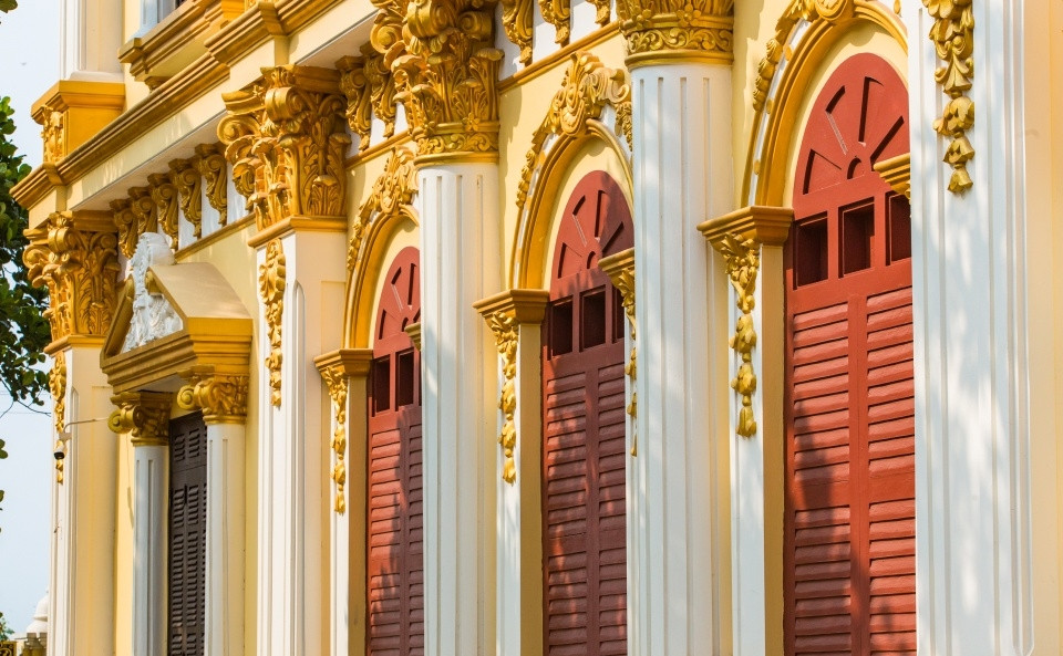 Cửa sổ hình vòm, sơn đỏ. Ban công các tầng, các cột trụ đều được gắn nhiều hình khối, họa tiết tinh xảo. Ảnh: Zing