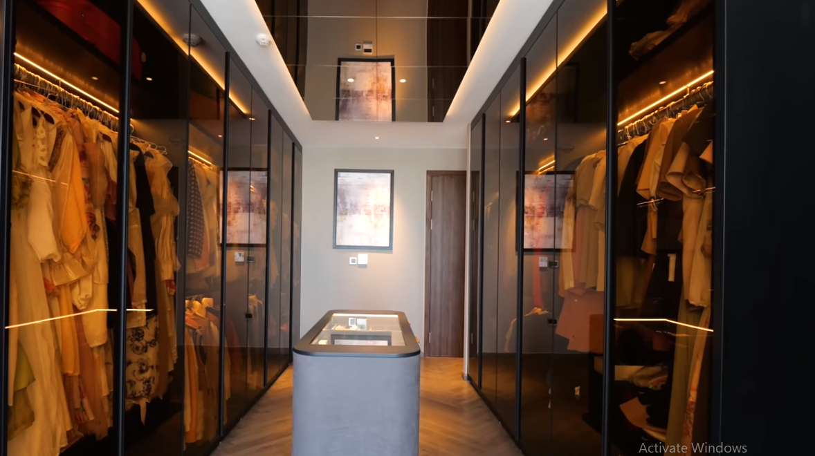 Trong phòng thay đồ, tủ quần áo với cánh kính tối màu, bên trong có đèn Led, vừa hiện đại vừa tinh tế và thuận tiện.