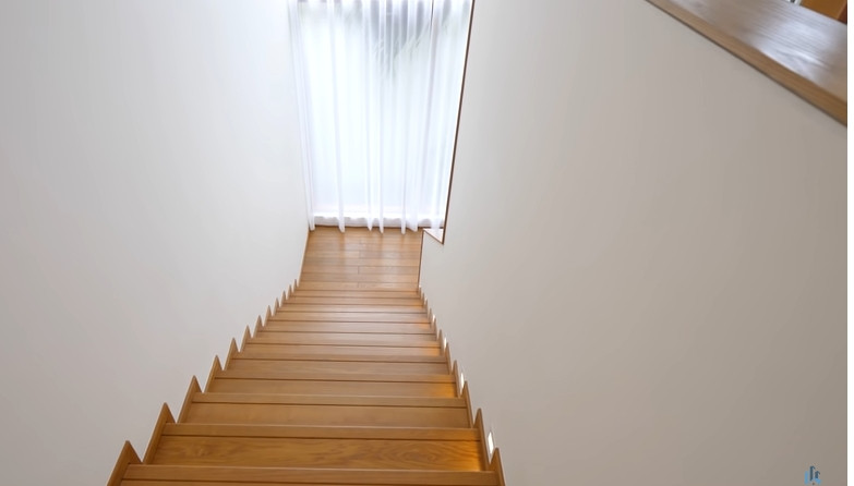 Cầu thang lên tầng 2 được ốp gỗ.