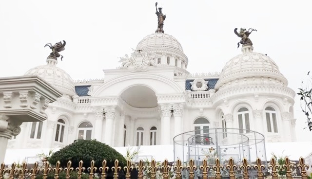 Mặt tiền căn biệt thự được thiết kế với những cột đá khổng lồ, ba mái vòm lớn và trên đỉnh có những bức tượng mạ vàng.