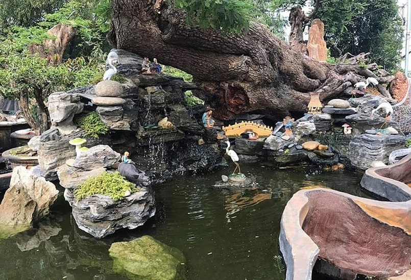 Phần bệ của cây me được tạo tiểu cảnh có nước chảy, có ông Tiên ngồi đàm đạo, có cậu bé chăn trâu và con cò. Ảnh: Người đưa tin