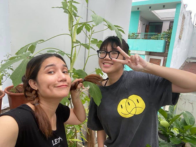 Hai mẹ con Cát Tường phấn khởi bên cây đậu bắp đang phát triển vượt trội. Ảnh: FBNV