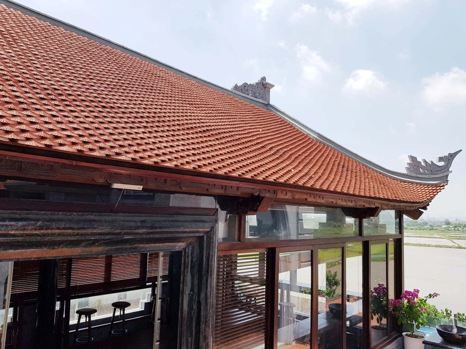 Phía trên tòa lâu đài được xây dựng nhà khung gỗ, mái ngói kiểu truyền thống tinh hoa văn hóa Việt. Ảnh: Dân trí