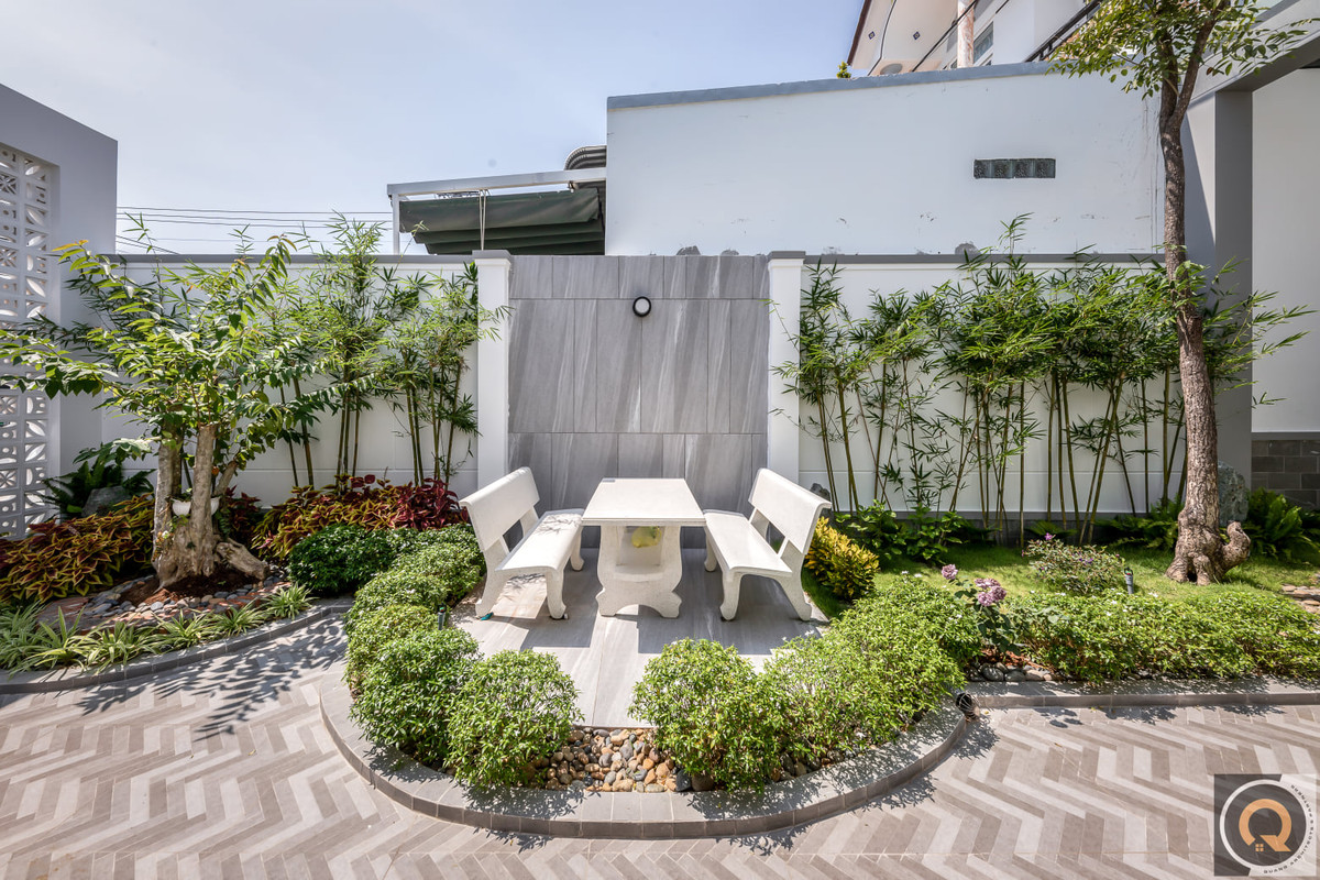 Không gian sân vườn ngập tràn cây xanh, có bàn ghế đá là không gian ngắm hoa, thư giãn tựa như trong một khu nghỉ dưỡng.