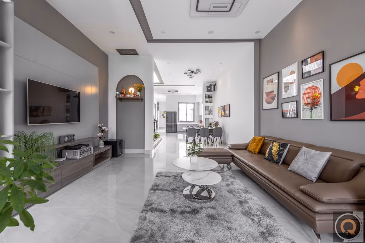 Ở bên trong căn nhà, phòng khách thoáng sáng, sử dụng gam màu trung tính chủ đạo.