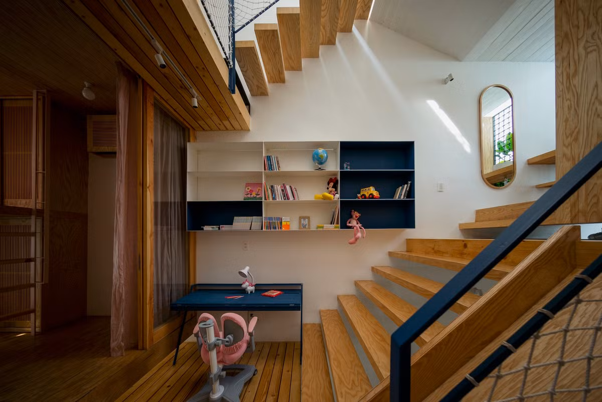 Theo đó, các không gian ở của gia đình và chỗ chơi của các con được sắp xếp đan xen vào nhau, đặt lên các lớp sàn gỗ thưa, bố cục so le, kết nối với nhau bằng hệ cầu thang như một “sân chơi” lớn, không có sự ngăn cách.