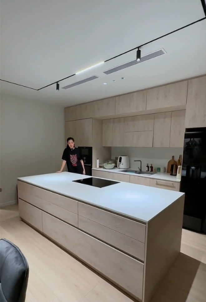 Khu bếp gây ấn tượng bởi hệ tủ gỗ sang trọng, đảo bếp và bàn ăn cỡ lớn. Nguồn ảnh: Chụp màn hình