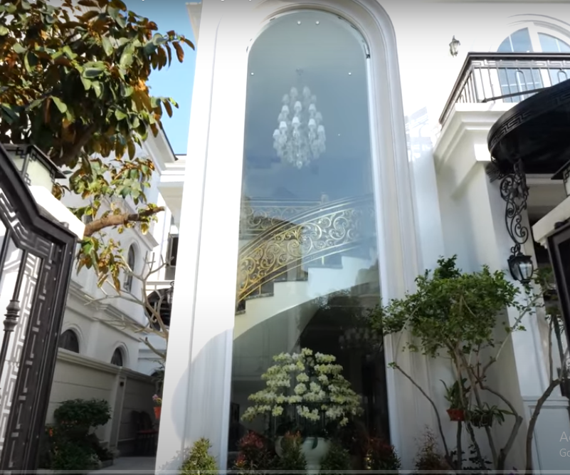 Điểm nổi bật nhất khi nhìn từ bên ngoài của căn biệt thự là cửa kính lớn kéo dài từ dưới lên trên, phô diễn cầu thang xoắn độc đáo ở bên trong.