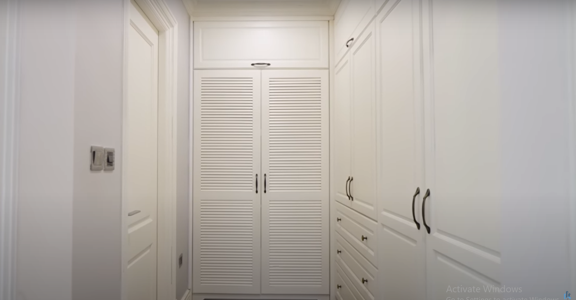 Phòng thay đồ trong phòng ngủ nhỏ xinh với chiếc tủ cao kịch trần.