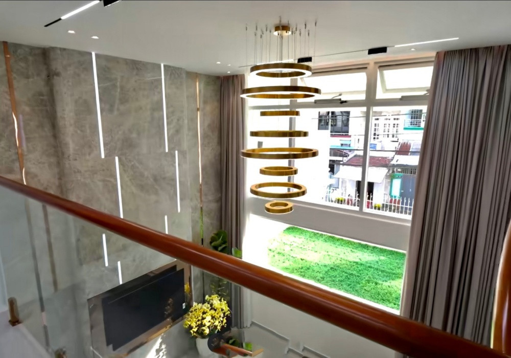 Mỗi tầng là không gian riêng tư cho một gia đình nhỏ, có thang máy và cầu thang uốn bọc inox màu đồng như một điểm nhấn trang trí. Ảnh: Vietnamnet